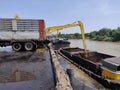 Excavator discharge coal to truck at jetty