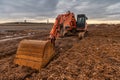 Excavator doing work on a wet and muddy winter day