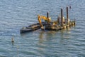 Excavator dredging on floating platform