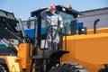 Excavator driver in hard hat stands at construction equipment, concept industrial man portrait Royalty Free Stock Photo