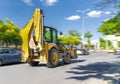 The excavator drives or goes fast on the street with heavy traffic with blue sky and green trees in background, Ankara, Turkey