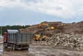 Excavator, dump truck and wheel loader at landfill for disposal of construction waste and concrete crushing. Recycling concrete