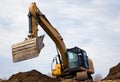 backhoe digging hydraulic shovel on construction site earth mover excavator dumping earth Royalty Free Stock Photo