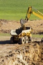 Excavator dumping soil and sand onto truck