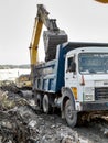 Excavator dumping waste materials in the dumper