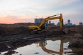 Excavator during earthmoving at construction site on sunset background. ÃÂ¡onstruction machinery for excavating. Small roughness Royalty Free Stock Photo