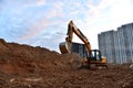 Excavator during earthmoving at construction site on sunset background. ÃÂ¡onstruction machinery for excavating. Tower cranes