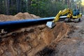 Excavator during earthwork for laying Crude oil and Natural gas pipeline in forest area. Installation of gas and crude oil pipes