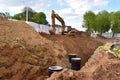 Excavator on earthwork during the laying of pipes of the heating system to a new residential building at the construction site.