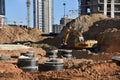 Excavator on earthwork during the laying of pipes of the heating system to a new residential building at the construction site.