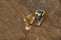 Excavator on earthworks. Backhoe on groundwork for road construction. Digger at construction site. Loader in open pit mining.