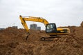 Excavator during earthworks at construction site. Backhoe digging the ground for the foundation and for laying sewer pipes Royalty Free Stock Photo