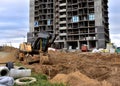 Excavator on earthworks. Laying heating pipes and stormwater in trench. Installing concrete wells, ÃÂhambers, manholes. Tower