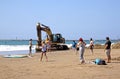 Excavator and Eight People on Beach in Durban