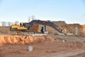 Excavator during excavation at construction site. Backhoe on foundation work in sand pit. Groundworks, site levelling,