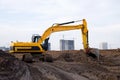 Excavator during excavation at construction site. Backhoe on road work. Heavy Construction Equipment Machines for Earthworks.