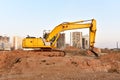 Excavator during excavation and road construction works at construction site on sunset background. Backhoe on foundation work in Royalty Free Stock Photo