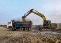 Excavator filling waste and sand into dumper