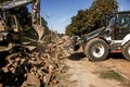 Excavator, grader and workers remove debris after dismantling a tram stop. Works on tram tracks