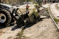 Excavator, grader and workers remove debris after dismantling a tram stop. Works on tram tracks