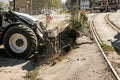 Excavator, grader and workers remove debris after dismantling a tram stop. Works on tram tracks