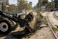 Excavator, grader and workers remove debris after dismantling a tram stop. Works on tram tracks