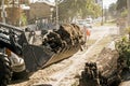 Excavator, grader and workers remove debris after dismantling a tram stop. Works on tram tracks