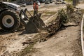 Excavator, grader and workers remove debris after dismantling a tram stop. Works on tram tracks