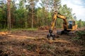 Excavator Grapple during clearing forest for new development. Tracked Backhoe with forest clamp for forestry work. Tracked timber
