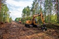 Excavator Grapple during clearing forest for new development. Tracked Backhoe with forest clamp for forestry work. Tracked timber Royalty Free Stock Photo