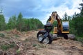 Excavator Grapple during clearing forest for new development. Tracked Backhoe with forest clamp for forestry work. Tracked timber