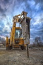 Excavator with hydraulic breaker hammer for the destruction of concrete and hard rock at the construction site or quarry.