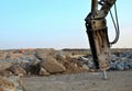 Excavator with hydraulic breaker hammer for the destruction of concrete and hard rock at the construction site or quarry. Royalty Free Stock Photo