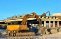 Excavator hydraulic crushes concrete slabs.