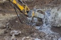 Excavator with hydraulic hammer breaking concrete 2