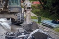 Excavator with hydraulic jack hammer  breaking asphalt in preparation for drainage works close up and selective focus Royalty Free Stock Photo