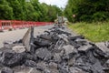 Excavator with hydraulic jack hammer  breaking asphalt in preparation for drainage works close up and selective focus Royalty Free Stock Photo