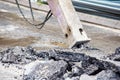 Excavator with hydraulic jack hammer  breaking asphalt in preparation for drainage works close up and selective focus Royalty Free Stock Photo