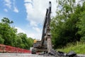 Excavator with hydraulic jack hammer  breaking asphalt in preparation for drainage works Royalty Free Stock Photo