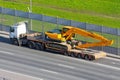 Excavator Hyundai robex 220 LC-95 Truck trailer loaded onto cargo platformon city highway. Russia, Saint-Petersburg. 19 may 2020