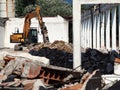 Excavator in a building under demolition, among rubble and dust, for an urban redevelopment . Royalty Free Stock Photo