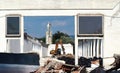 Excavator inside a building under demolition, among rubble and dust, for an urban redevelopment Royalty Free Stock Photo