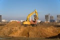 Excavator load the sand to the dump truck on construction site. Backhoe digs the ground for the foundation and construction Royalty Free Stock Photo