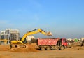 Excavator load the sand to the heavy dump truck on construction site. Excavators and dozers digs the ground for the foundation