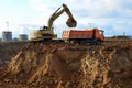 Excavator load the sand to the heavy dump truck on construction site. Excavators and dozers digs the ground for the foundation