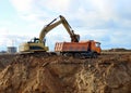 Excavator load the sand to the heavy dump truck on construction site. Excavators and dozers digs the ground for the foundation