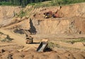 Excavator load the sand to the heavy mining truck in the open-pit. Heavy machinery working in the mining quarry. Digging and Royalty Free Stock Photo