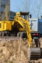 Excavator loader and dump truck during earthworks at a construction site. Loading land in the back of a heavy truck. Royalty Free Stock Photo
