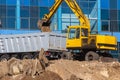 Excavator loader and dump truck during earthworks at a construction site. Loading land in the back of a heavy truck. Royalty Free Stock Photo