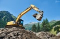 Excavator loader machine at construction earthmoving work in mountains Royalty Free Stock Photo